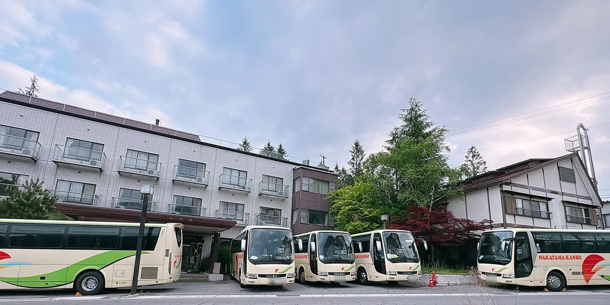 建物の前に並ぶ大型バス